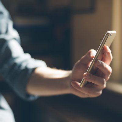 A hand holding a phone, texting.